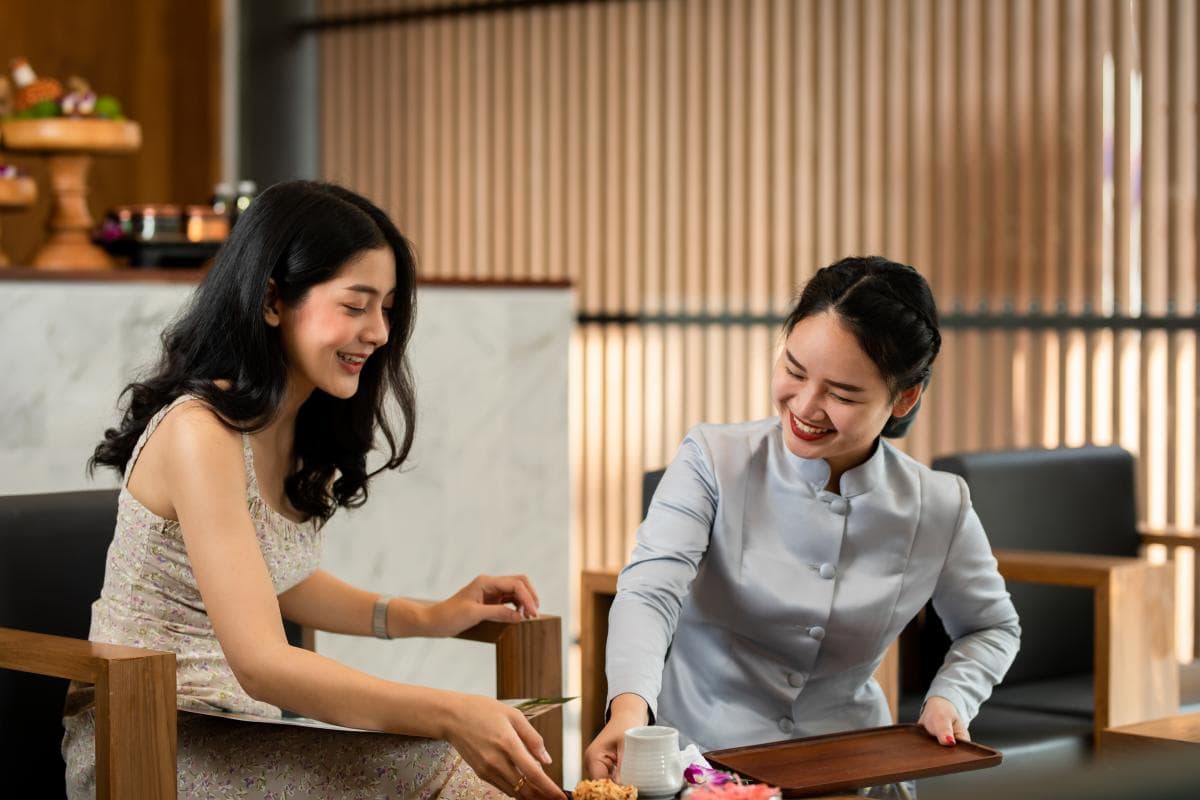 マッカ・ヘルス&スパのセラピストがゲストに温かいお茶を提供している。