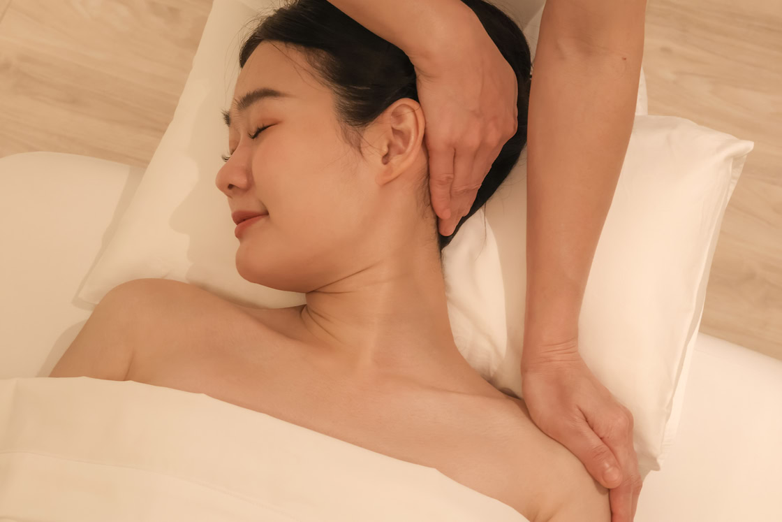 A relaxed woman receiving a Thai facial treatment in Bangkok