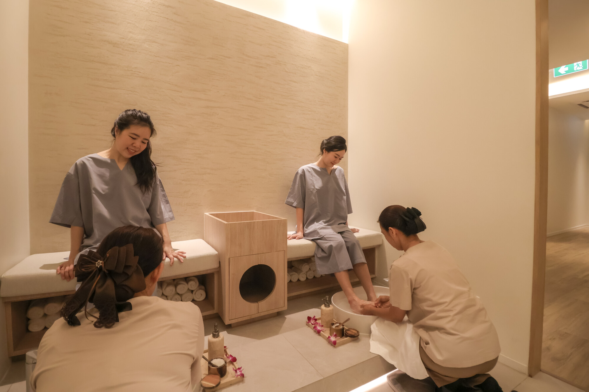 Spa therapist washing women’s feet before 4-hands Indian foot massage