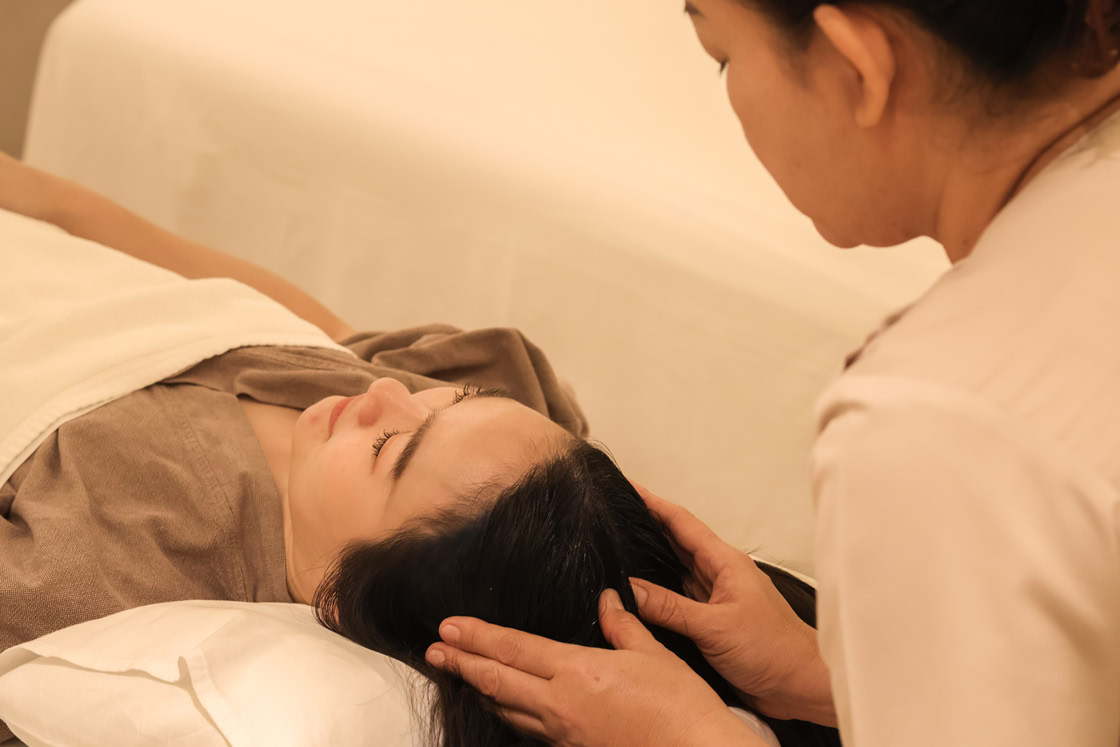 A therapist providing an Indian head massage