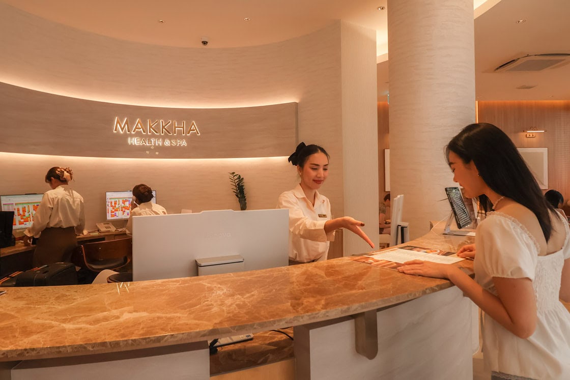 A woman selecting massage treatment from spa menu