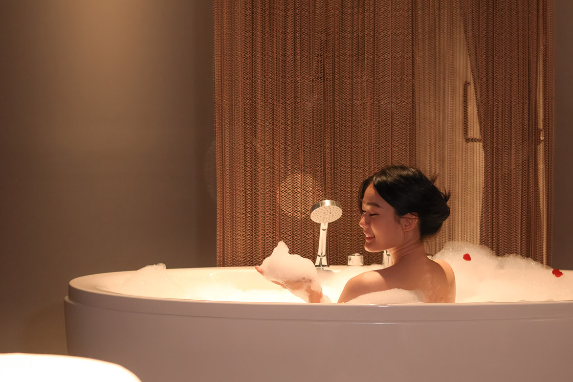 A woman enjoying a milky bath spa at Makkha Health & Spa