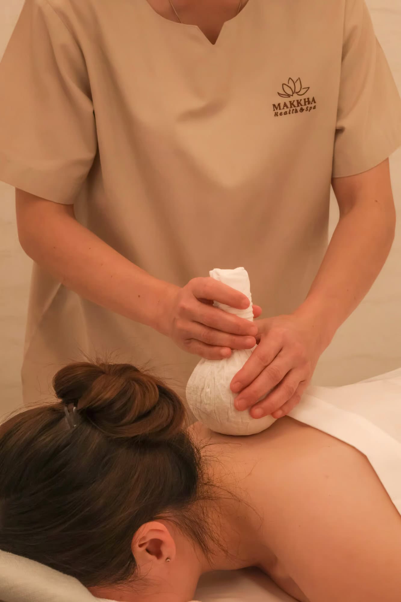 Relaxing Thai herbal compress massage at Makkha Spa in Chiang Mai, offering traditional healing treatments in a tranquil spa environment.
