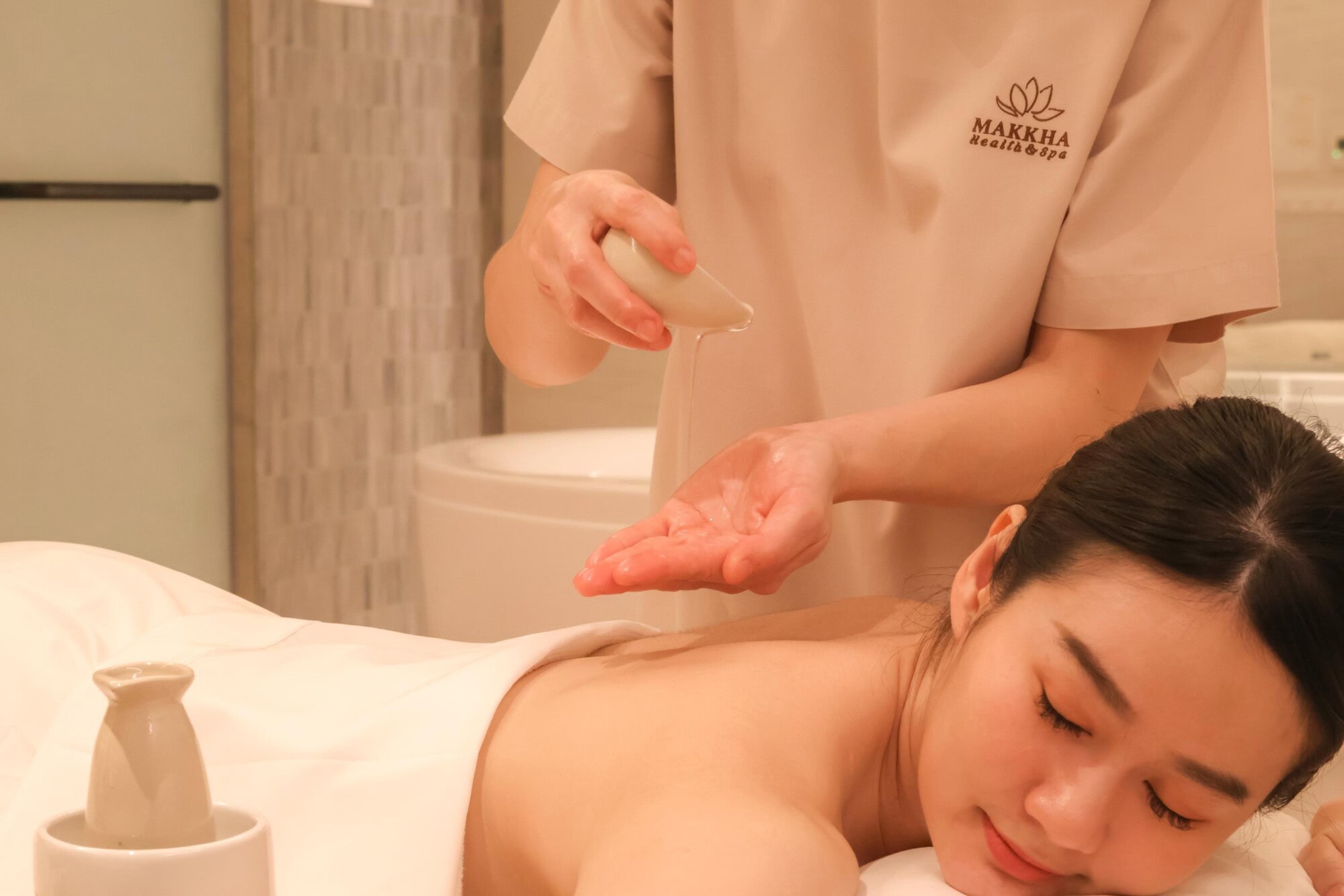 A therapist pouring essential oils during an aroma oil massage