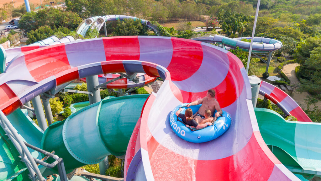 Relaxing scene at Makkha Spa in Chiangmai featuring a family enjoying a thrilling water slide ride surrounded by lush greenery. Perfect for a refreshing and fun spa experience in northern Thailand.