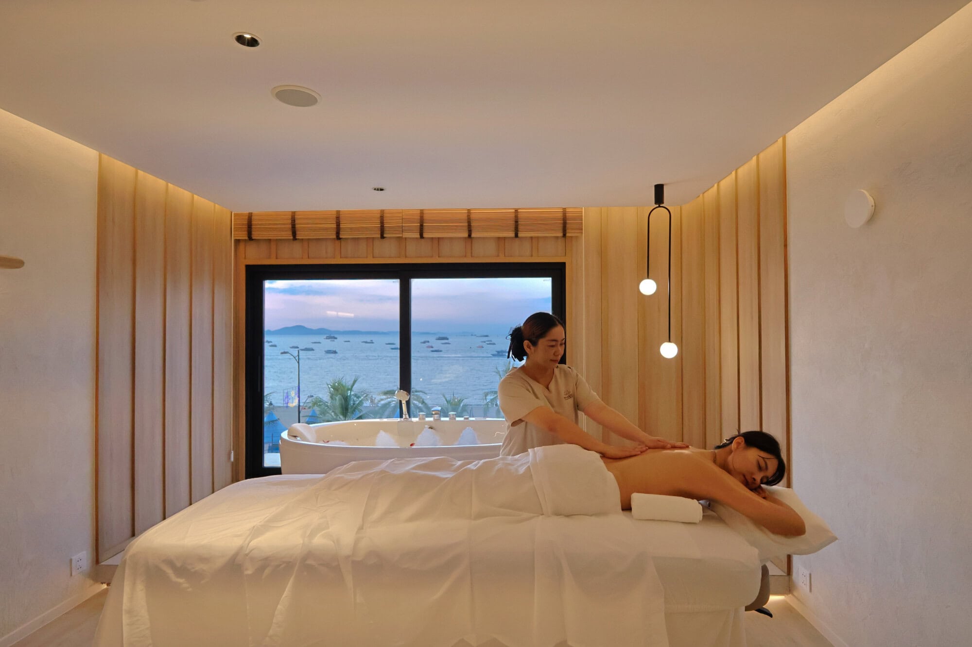 Relaxing massage session at Makkha Spa in Chiangmai with a scenic view through large windows.