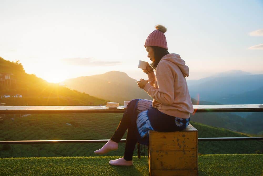 A woman enjoying coffee with a mountain view in Chiang Mai