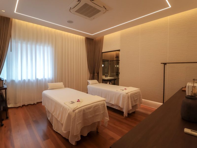 Relaxing massage room at Makkha Spa in Chiang Mai featuring two massage beds, warm ambient lighting, and modern decor for a luxurious spa experience.