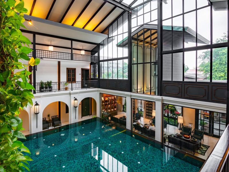 Luxurious indoor swimming pool at Makkha Spa with elegant architecture and natural lighting in Chiang Mai.