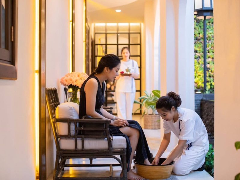 Relaxing Thai foot massage at Makkha Spa in Chiangmai, featuring a woman receiving foot treatment by a professional therapist in a tranquil, modern spa environment.