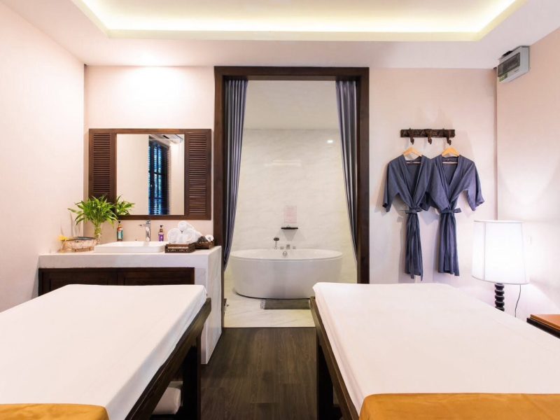 Luxurious spa room with two massage beds, a private bathtub area, and relaxing bathrobes, creating a serene atmosphere for ultimate relaxation at Makkha Spa in Chiang Mai.