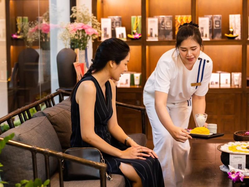 Luxurious spa treatment at Makkha Spa Chiang Mai with an attentive therapist preparing a relaxing herbal therapy for a guest. Enjoy authentic Thai massage experiences in a serene setting.