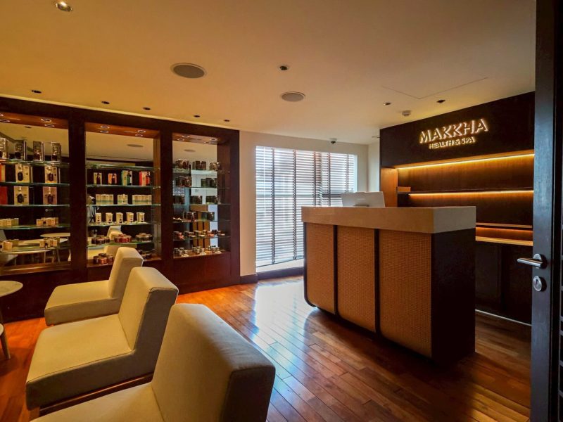 Luxurious Chiang Mai spa reception area with warm lighting, comfortable seating, and an elegant display of skincare products, offering the best relaxation experiences at Makkha Spa.