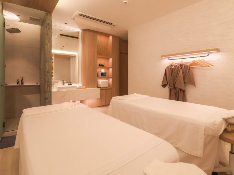 Relaxing spa treatment room at Makkha Health and Spa in Chiang Mai, featuring two massage beds, contemporary decor, soothing lighting, and a comfortable ambiance for ultimate relaxation.
