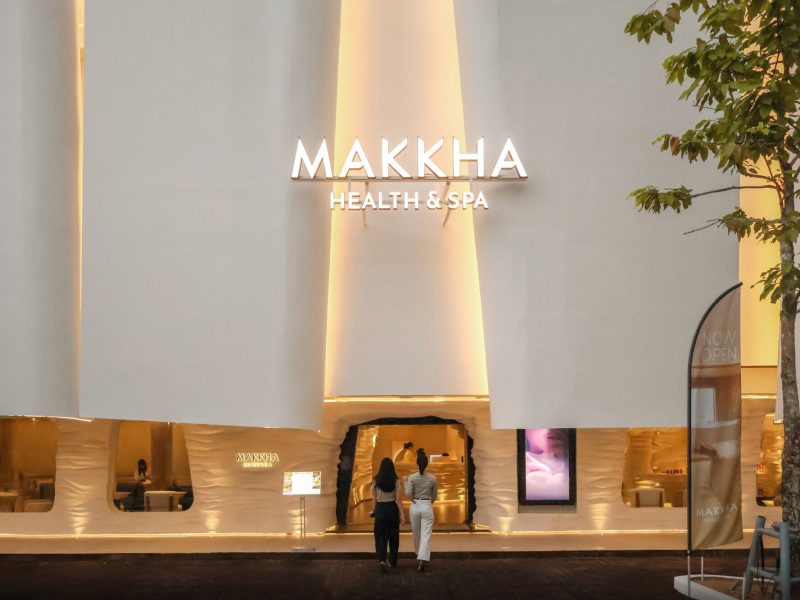 Modern exterior view of Makkha Health & Spa building in Chiang Mai with illuminated signage and welcoming entrance, showcasing a luxurious spa experience.
